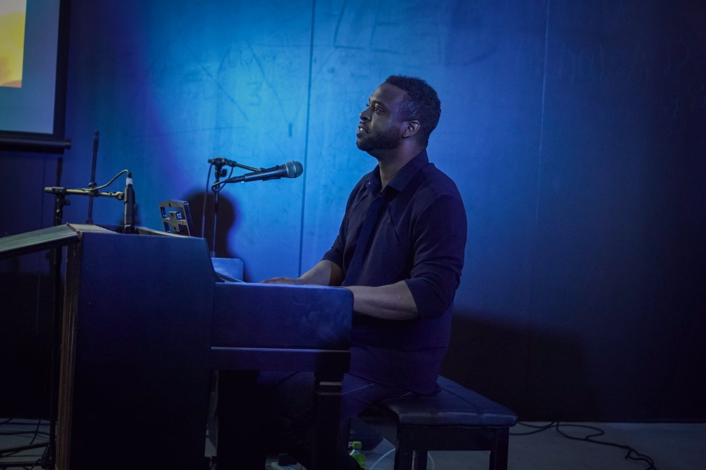 RAHAM at the piano under blue stage light