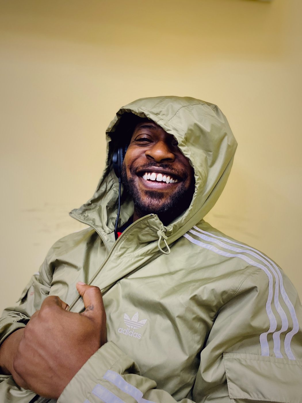 Smiling portrait of RAHAM in a hooded jacket